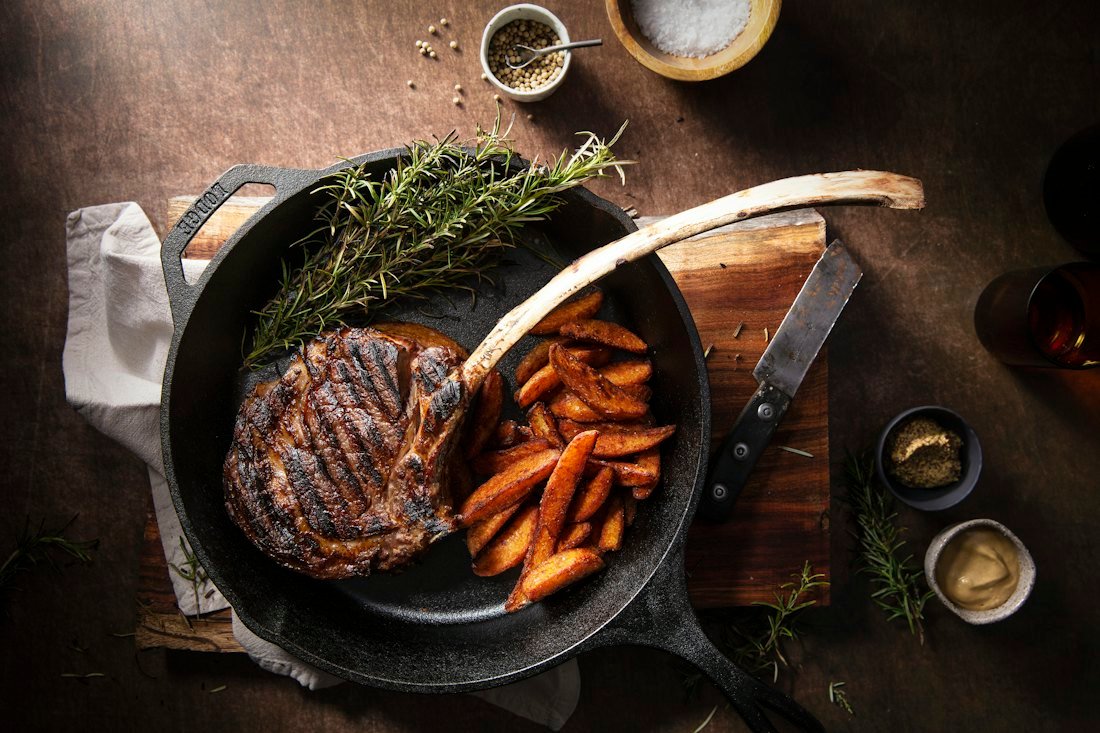 Bone-in chop seared in a cast iron skillet with rosemary