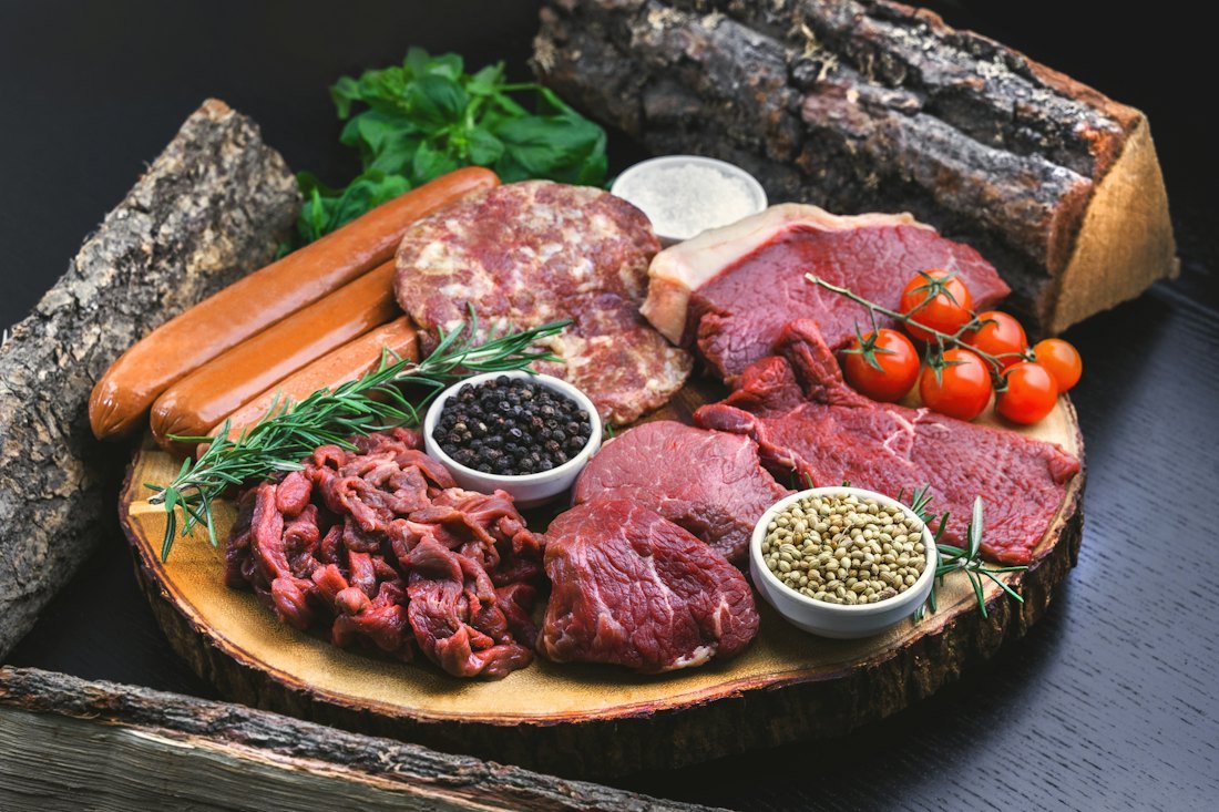 Assortment of sausages and raw meats on a board