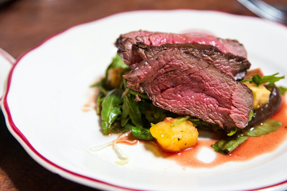 Sliced medium-rare steak plated at a restaurant